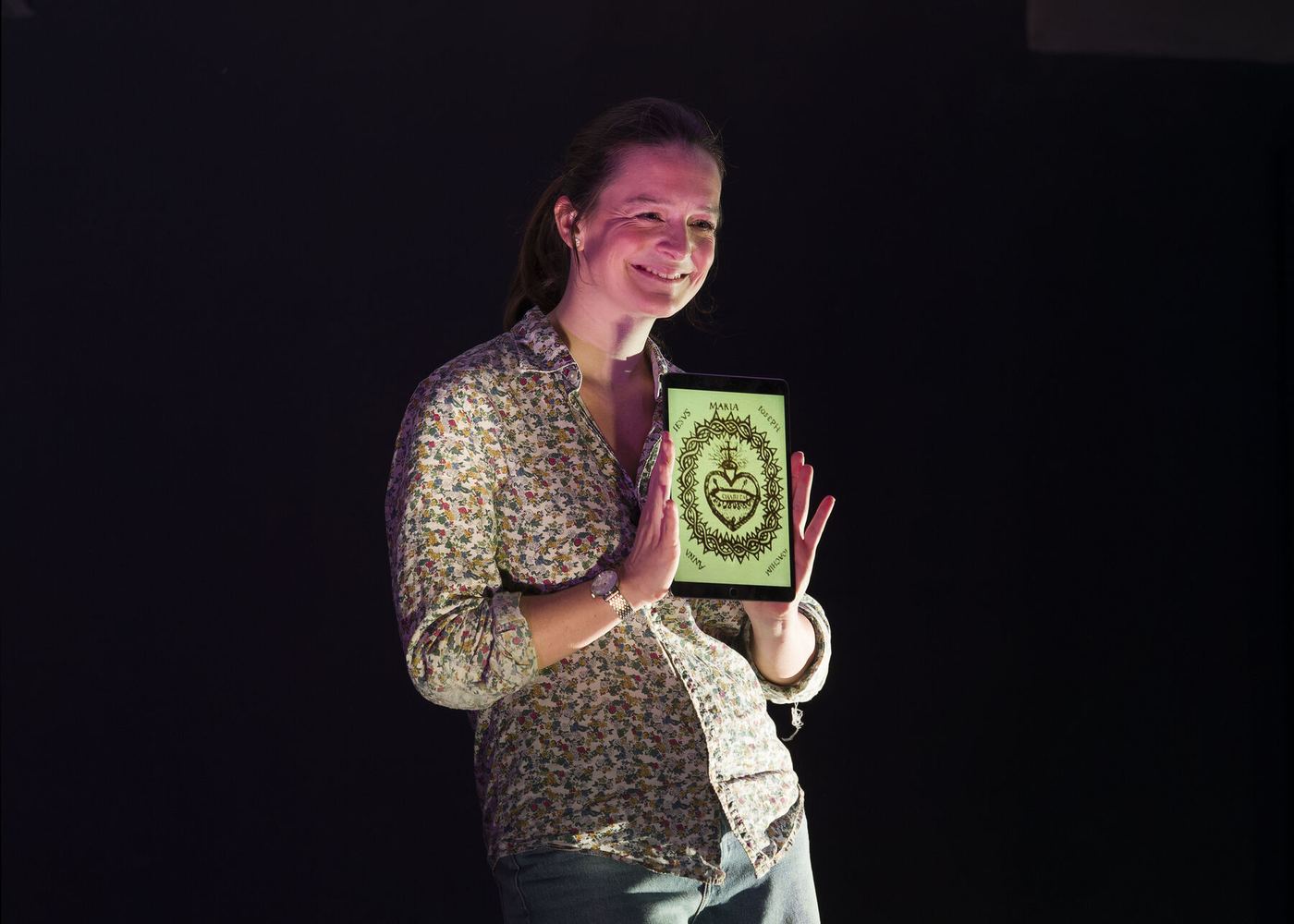 Sybille Montagne tient un livre et sourit au public